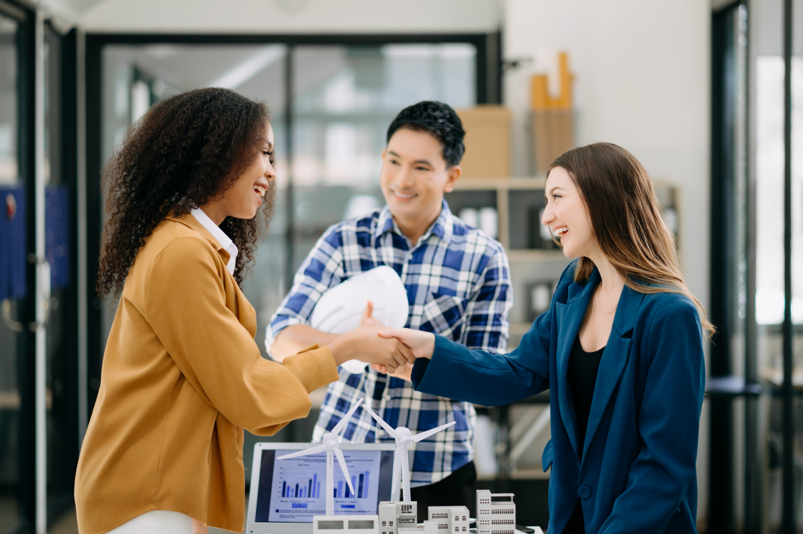 A young sales representative shaking hands with a client after closing a deal.