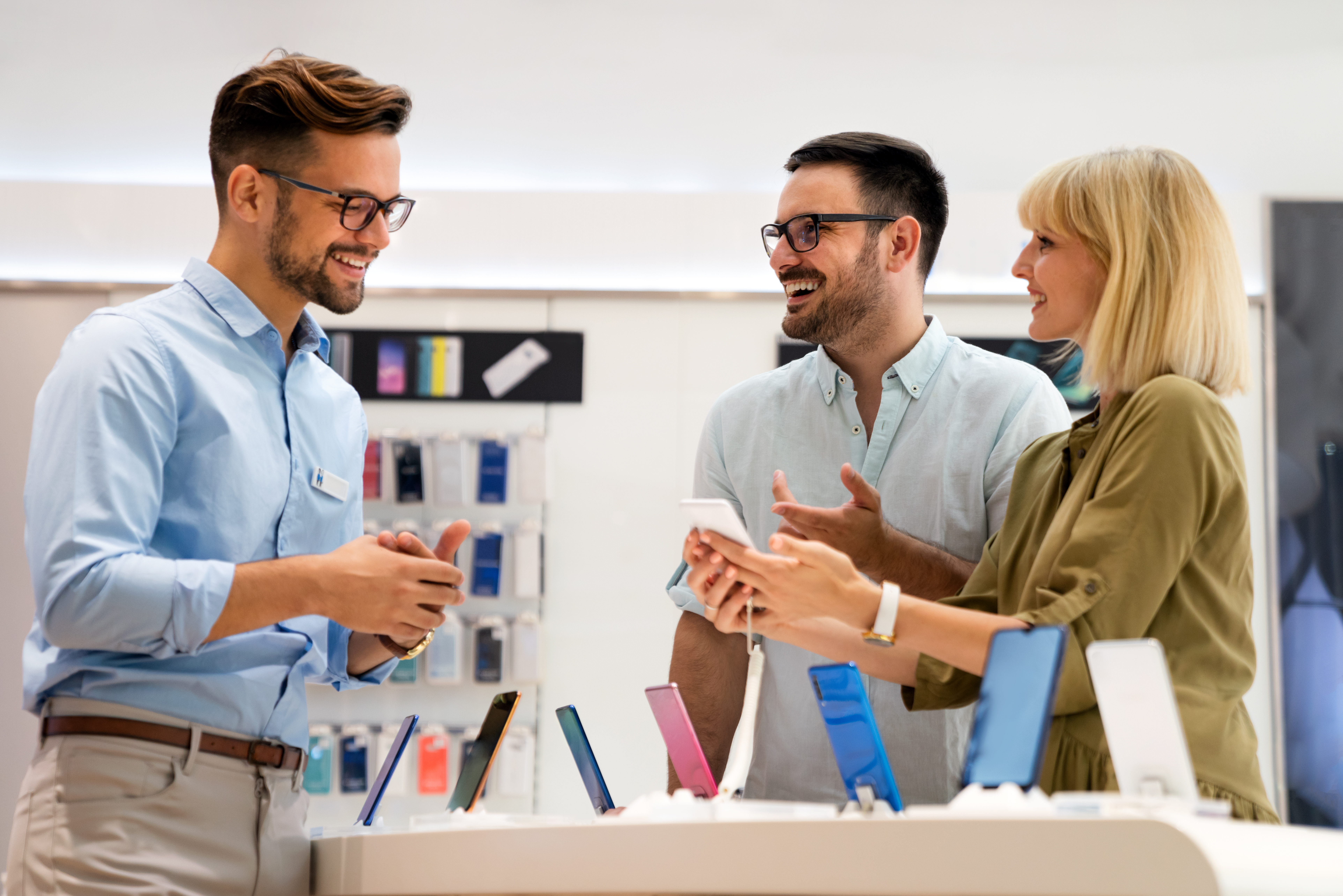 A sales representative educating customers in a smartphone store